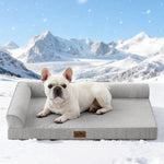 Dog lying on Cozy Kiss grey pet bed with a snowy mountain landscape in the background