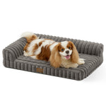 Front view of a dog resting on the Cozy Kiss Striped Faux L-Shaped Washable Dog Bed, showing the raised bolster design. 