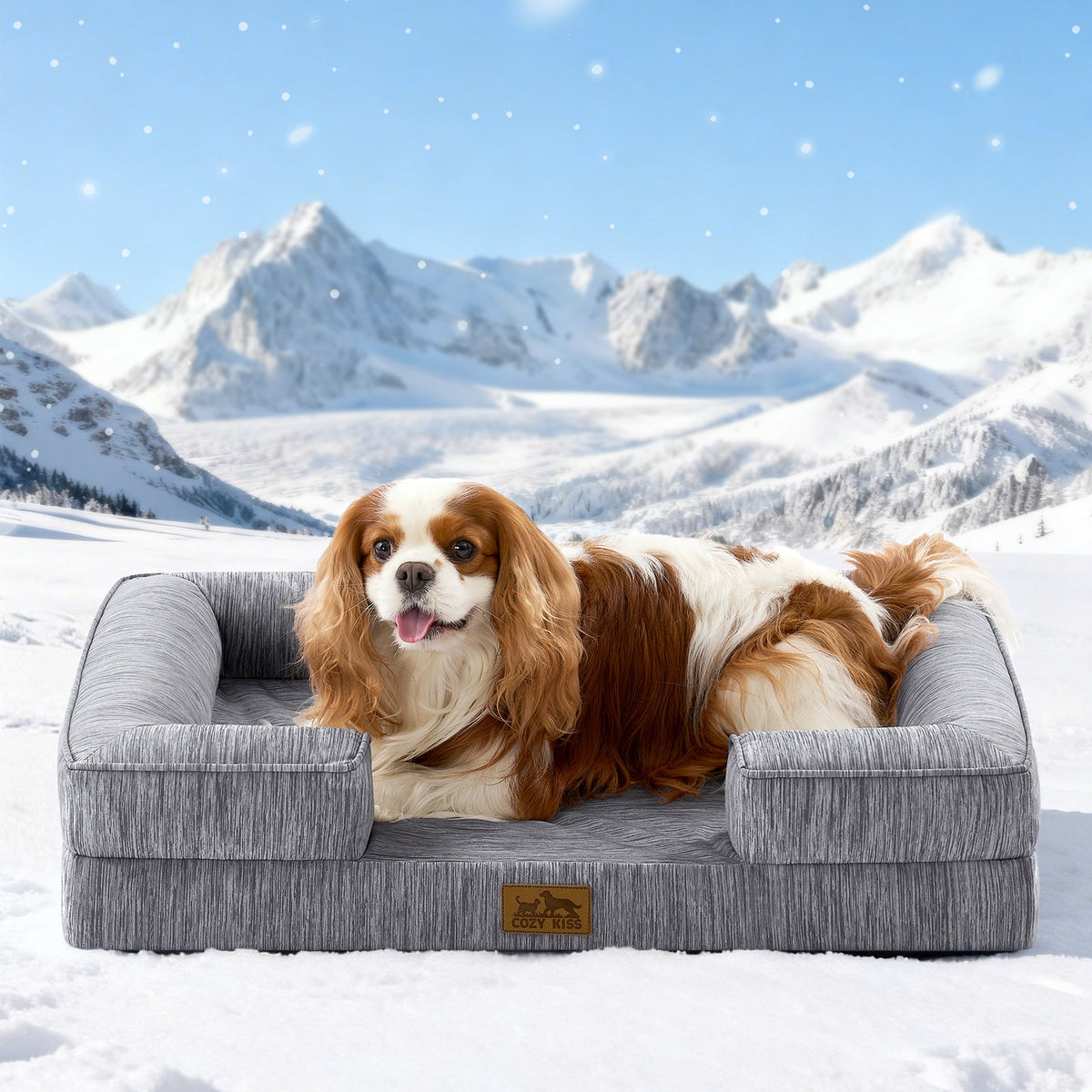 Dog lying on Cozy Kiss grey pet bed in a snowy landscape with mountains.