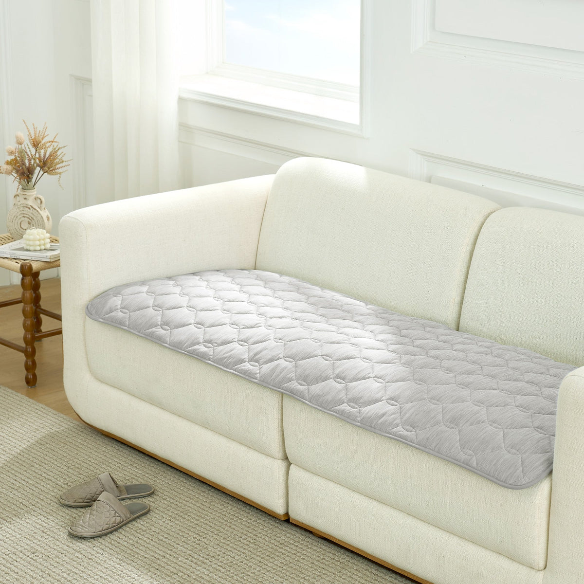Gray couch cover on a white sofa in a living room setting.