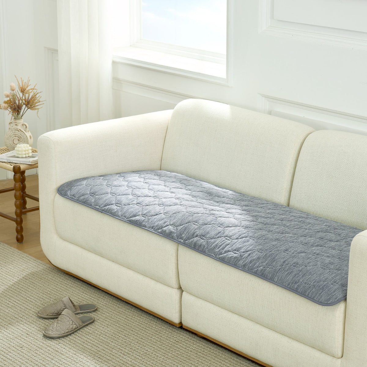 Cozy Kiss grey couch cover on a white sofa in a living room setting.