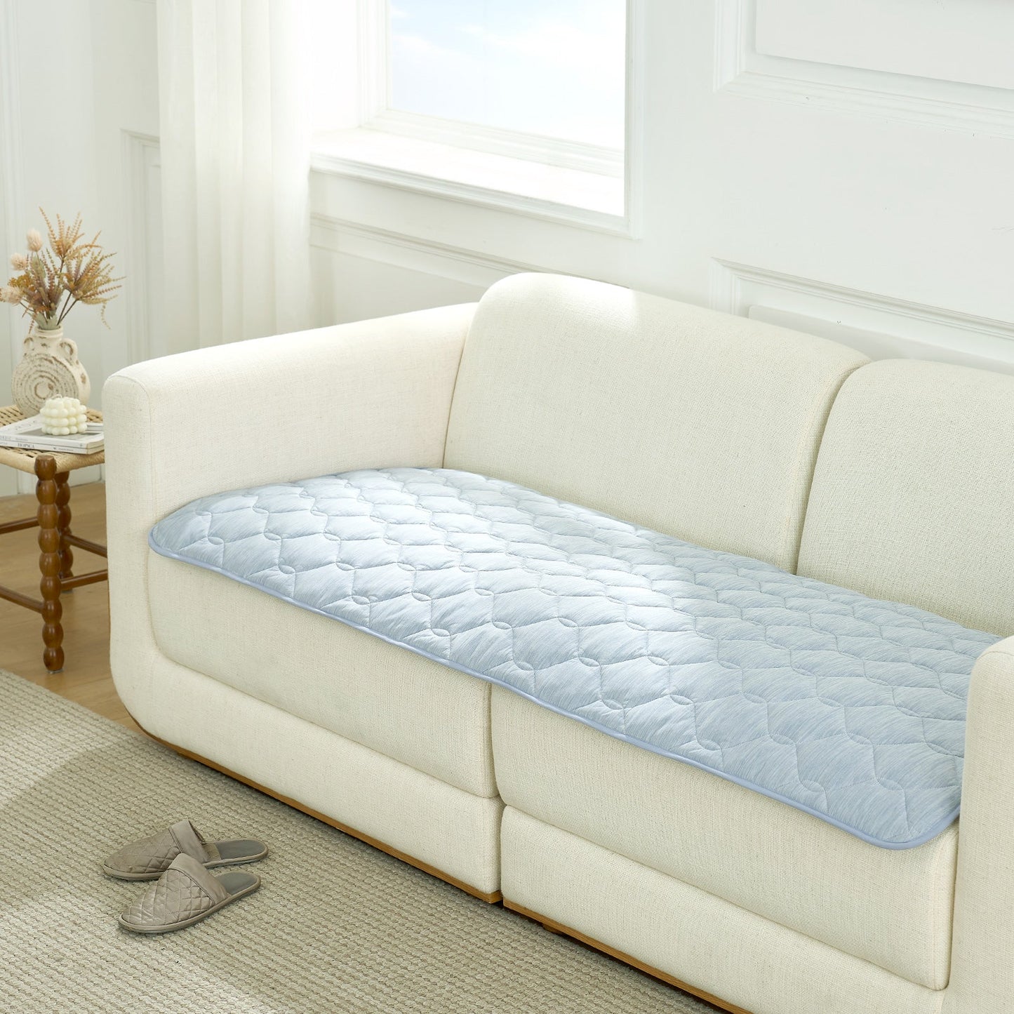 Blue couch cover on a white sofa in a living room setting.#Color_Sky Blue
