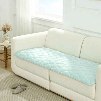 Green couch cover on a white sofa in a living room setting.#Color_Sage Green